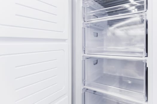 Empty white vertical new freezer with drawers