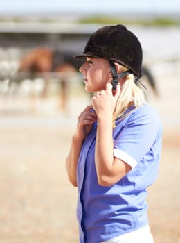 Woman prepare, horse jockey and helmet of young athlete on equestrian training ground for show and race. Outdoor, female person and equipment fixing on animal farm for dressage with rider and horses