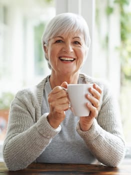 Portrait, happy old woman and drinking coffee in home for break, relaxing morning and retirement. Face, laughing and senior lady enjoy cup of tea, warm beverage and hot drink in house with happiness