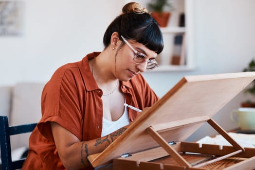 Do something creative each day. an artist sketching in a desk easel at home.