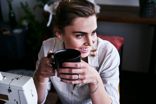 Caffeine makes me even more creative. a fashion designer having coffee at her desk.