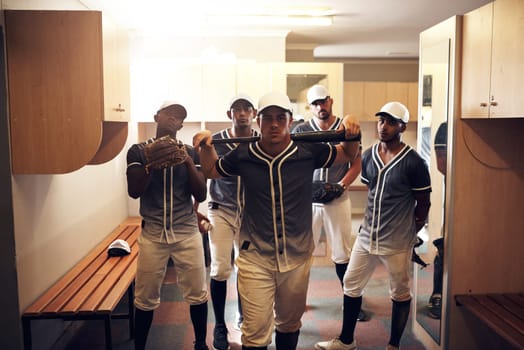 The best teams move together as one. a group of young men walking into a locker room at a baseball game.