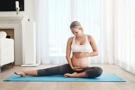 Are you ready for a little workout. a pregnant woman meditating on an exercise mat at home.