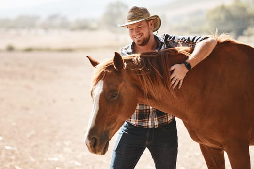 Hes developed a special bond with horses. a farmer standing with a horse on a ranch.