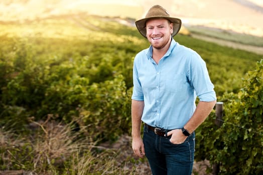 Im happiest when Im out here. Portrait of a farmer standing in a vineyard.