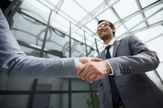 Delighted businessmen shaking hands, greeting acquaintance in the office,