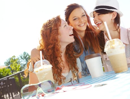 I can achieve anything with my friends support. A group of adolescent girls enjoying smoothies at an outdoor cafe.