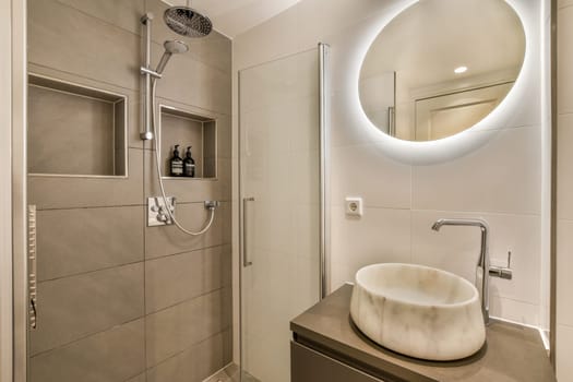 a bathroom with a sink and shower and a mirror