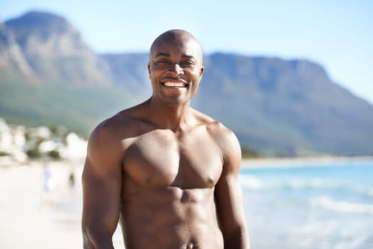 Fit and confident. A muscular african-american man smiling at the beach.