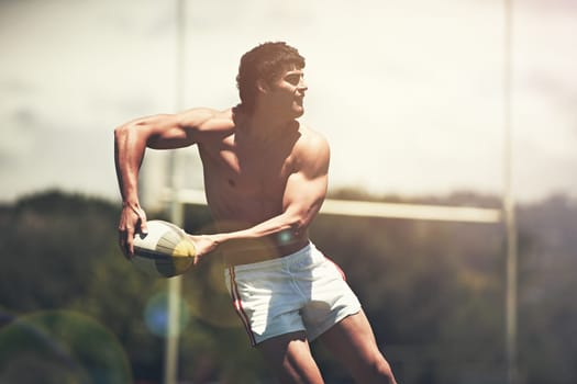 Hes the pass master. a shirtless rugby player executing a pass during a game.