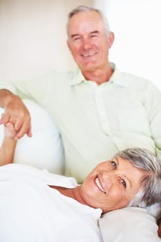 Loving mature couple together. Portrait of loving woman lying on mans lap at home.
