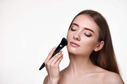 lovely lady posing with make-up brush for powder