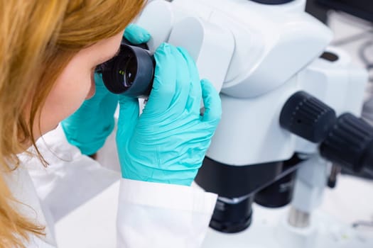 A scientist is utilizing a microscope, embodying the concepts of medical healthcare technology and pharmaceutical research and development.