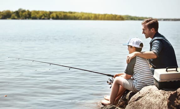 Enjoying their first fishing adventure together. a father and his little son fishing together.