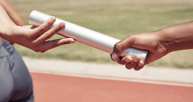 Hands, team and sports relay baton for running, sprint or fitness marathon for olympic athletics on stadium track. Hand of runner holding bar in teamwork sport for run, race or competition of speed