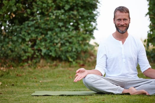 Love your whole being. Portrait of a handsome mature man smiling while doing yoga in the outdoors