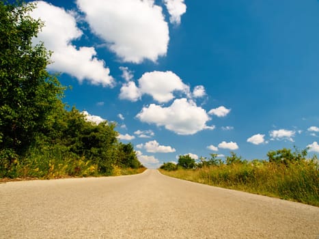 Countryside road, outdoor landscape and sky with clouds, summer sunshine and background in nature. Street, asphalt and spring with mockup space, trees and plants from low angle in natural environment.
