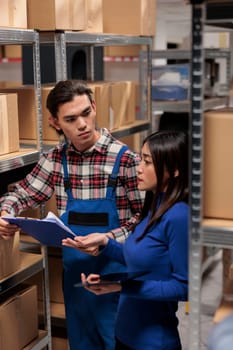 Asian man and woman doing warehouse logistics management together