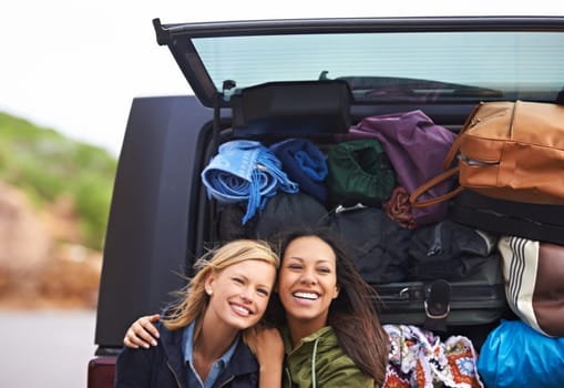 Camping with my best friend. A shot of two young woman standing in front of a car full of luggage.