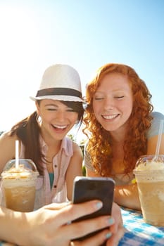 Take a look at this. Two adolescent girls enjoying smoothies while texting on a cellphone.