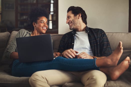 Laptop, relax and an interracial couple streaming a movie using an online subscription service for entertainment. Computer, watching or internet with a man and woman bonding together over a video