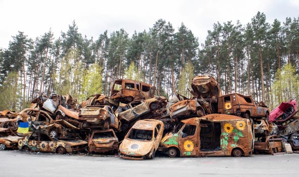 A lot of burnt fired cars in the parking lot, the consequences of the invasion of Ukraine. War in Ukraine. Cemetery of destroyed cars of civilians who tried to evacuate from the war zone.