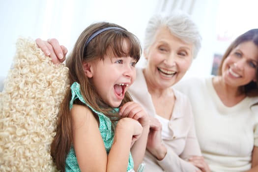 Its the tickle monster. a cute little girl spending time with her mother and grandmother at home.