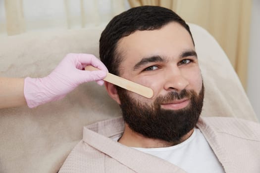 Man getting ready for a laser hair removal on his face at cosmetologist