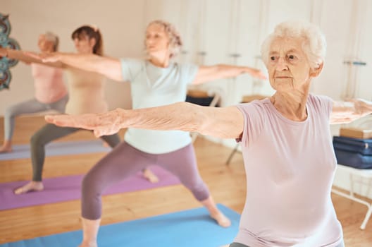 Exercise, yoga and group of senior women in gym training for fitness, healthcare and wellness. Pilates, meditation and retired females stretching arms in fitness center for balance workout together.
