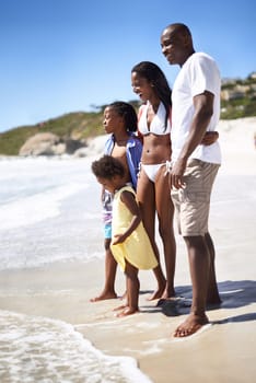 Its not cold at all. An african-american family enjoying a day at the beach together.