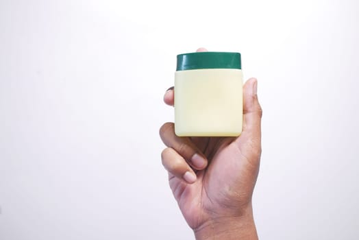 hand holding a petroleum jelly container