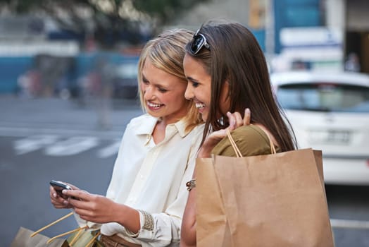 Shopping, smartphone and urban friends happy for sale announcement, women clothes deal or online retail promotion. Store product, city and customer check fashion discount notification on social media.