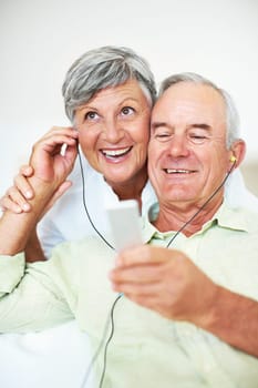 Cheerful mature couple listening music. Cheerful mature couple listening music at home.