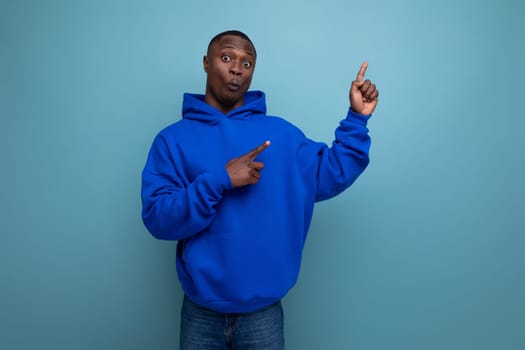 authentic ethnic young african man in stylish hoodie on blue background