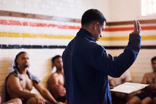 Listen up, the coach has something to say. a rugby coach addressing his team players in a locker room.