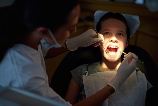 Its not as scary as it looks. Closeup shot of a young girl having a checkup at the dentist.