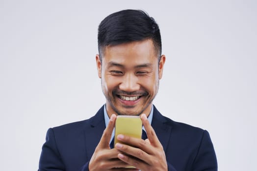 Connectivity is key. Studio shot of a young man using a mobile phone against a grey background.