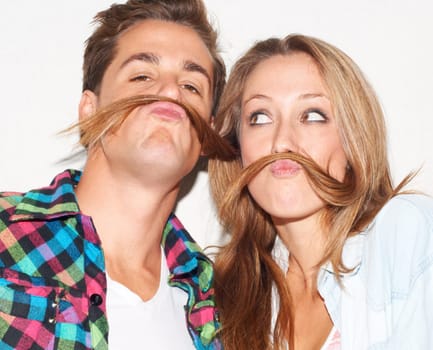 Playful, portrait and couple with hair mustaches being funny, comic and quirky together in a studio. Crazy, young and a man and woman being silly and goofy on a date isolated on a white background