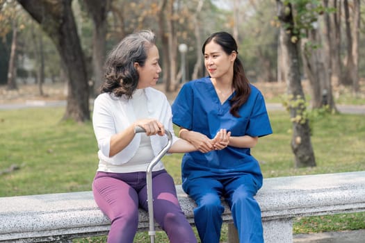 Female nurse checking hands, massaging the hands of the elderly Caring for the hospital park