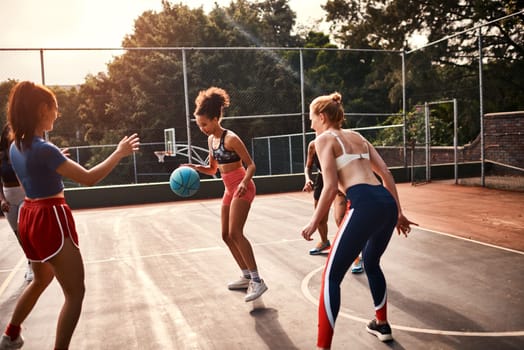 Adding the pressure. a diverse group of sportswomen playing a competitive game of basketball together during the day.
