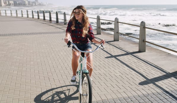 Make time for the things that set your soul on fire. a beautiful woman out on the promenade with her bicycle.