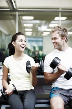 Working out together. two people working out using dumbbells in the gym.