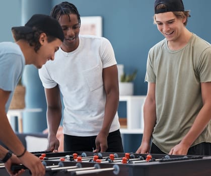 Student foosball, friends and men playing a game at students accommodation at university. Board, soccer and guys with happiness and fun competition together in a lounge playing on sports table