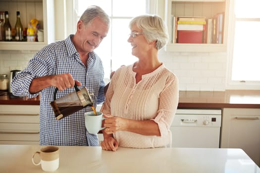 Happy, coffee or old couple talking in a kitchen at home bonding or enjoying quality morning time together. Love, wellness or mature man in conversation, relaxing or drinking espresso tea with woman