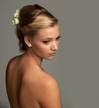 Elegance and natural beauty. Studio shot of an attractive young woman isolated on gray.