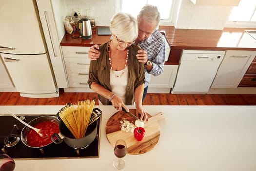 Affection, support or old couple kitchen cooking with love or healthy food for lunch together at home. Hug, embrace or above of senior woman helping an elderly romantic husband in meal preparation