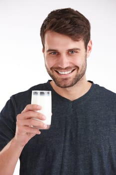 Keeping up those calcium levels. Studio portrait of a smiling man holding a glass of milk.