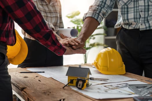 construction team handshake greeting start new project contract plan in office center at construction site partner and contractor yellow hard hat on table and house design print design