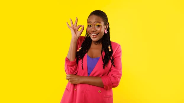 Positive African American Woman Gesturing Okay Standing Over Yellow Background