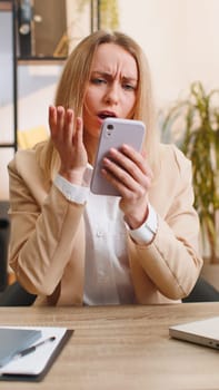 Young office business woman use smartphone surprised by bad news, fortune loss, fail lottery results